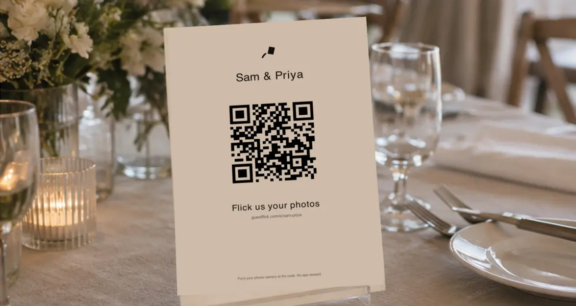 A printed GuestFlick sign with a QR code standing on a set table